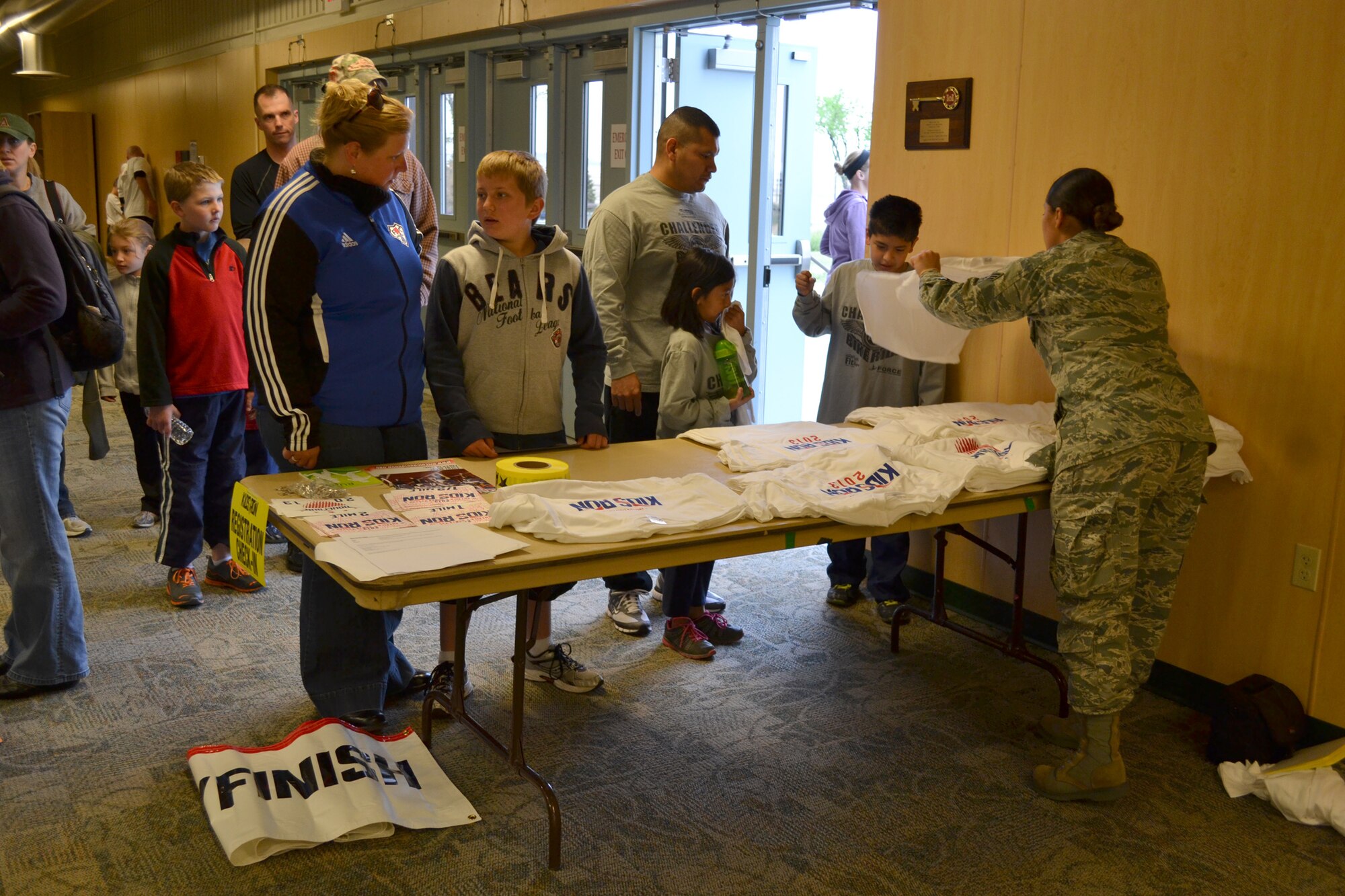 Senior Airman Miriam Santiago, 341st Force Support Squadron fitness specialist, hands out event T-shirts to children participating in the Armed Forces Kids’ Run at the Malmstrom Fitness Center on May 18.  Children of all ages were able to run a 1/2-mile, one-mile or two-mile run during the event.  (U.S. Air Force photo/Senior Airman Cortney Paxton)