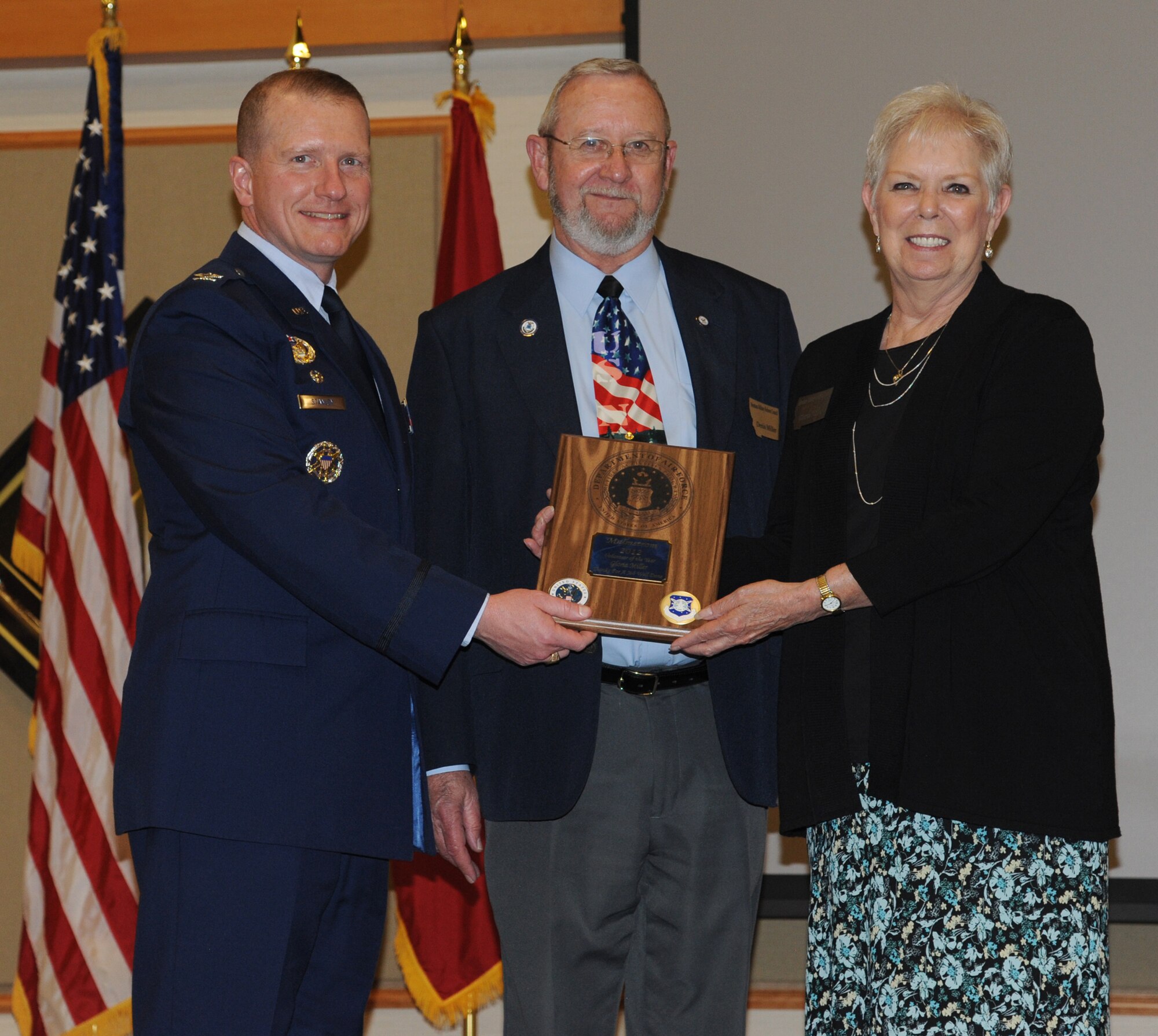 Col. Robert Stanley, 341st Missile Wing commander (left), and Dennis Miller, Montana Military Retiree’s Council director, present the 2012 Malmstrom Volunteer of the Year award to Dennis’ wife, Gloria, during the Retiree Appreciation Dinner at the Grizzly Bend on May 18. (U.S. Air Force photo/Airman 1st Class Katrina Heikkinen)