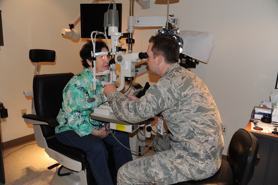 Capt. Joshua Hager, 341st Medical Operations Squadron optometrist, performs an eye exam on Marie Grey at the clinic May 18. Retirees and their dependents had the opportunity to receive numerous health screenings during the annual Retiree Appreciation Weekend including heel scans measuring bone density, body mass index exams and healthy eating options. (U.S. Air Force photo/Airman 1st Class Katrina Heikkinen)