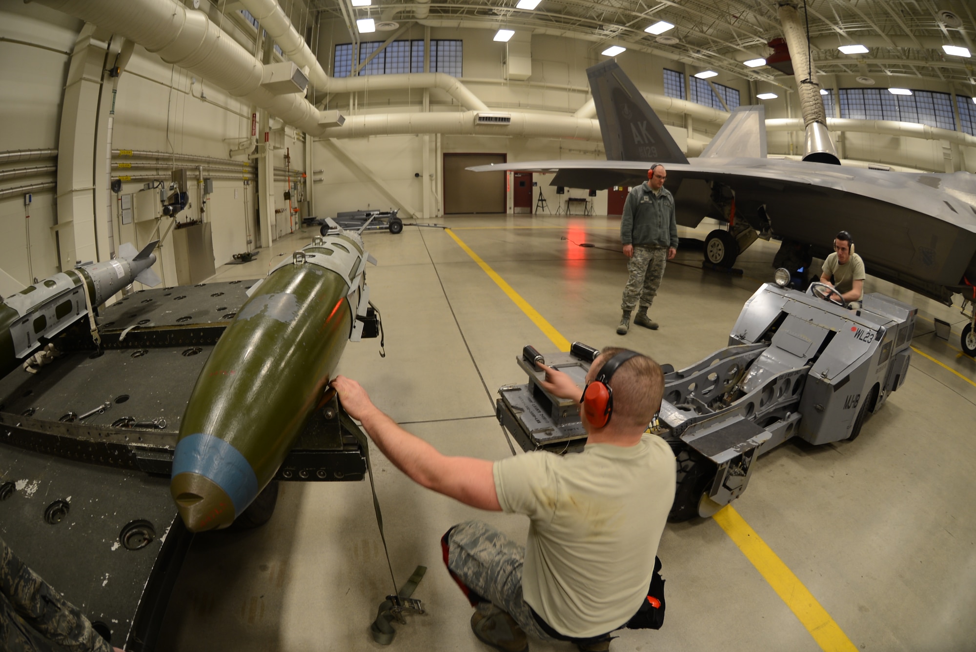 Tech. Sgt. Anthony Cords evaluates Senior Airman Joshua Baker as he picks up
a GBU-32 Joint Direct Attack Munition with a jammer while Staff Sgt. Brandon
Vice gives him directions during the 2012 JBER F-22 Weapons Load Competition. Vice and Baker are weapons loaders assigned to the 477th Aircraft Maintenance Squadron. Their three man crew was recently awarded the 20122 JBER F-22 Weapons Load Crew of the Year.(U.S. Air Force/ Tech. Sgt. Dana Rosso)
