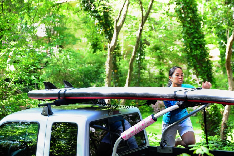 Maj. Elisa Hammer, 779th Aeromedical Squadron Bioenvironmental Engineering Flight chief, secures her paddleboard to her truck May 3, 2013, at her home in Mount Vernon, Va. "After a long week of work, it's nice to spend the weekend on the water," Hammer said. "It really relaxes me, it refreshes my spirit and it takes me away from the stress. I forget about the desk, I forget about e-mail and I'm out here on the water--just me and my board." (U.S. Air Force photo by Senior Airman Steele C. G. Britton)