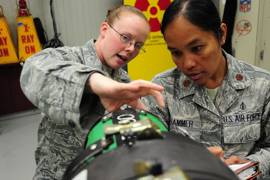 Maj. Elisa Hammer, 779th Aeromedical Squadron Bioenvironmental Engineering Flight chief, and Staff Sgt. Jesse Ford, 779th AMDS bioenvironmental engineering technician, inspect equipment in the X-ray survey vault, May 2, 2013, at Joint Base Andrews, Md. Hammer?s team also works regularly in aircraft maintenance hangars measuring chemical exposures in fuel cells and tests airflow in ventilation systems while validating proper protective clothing and respirators. (U.S. Air Force photo by Senior Airman Steele C. G. Britton)