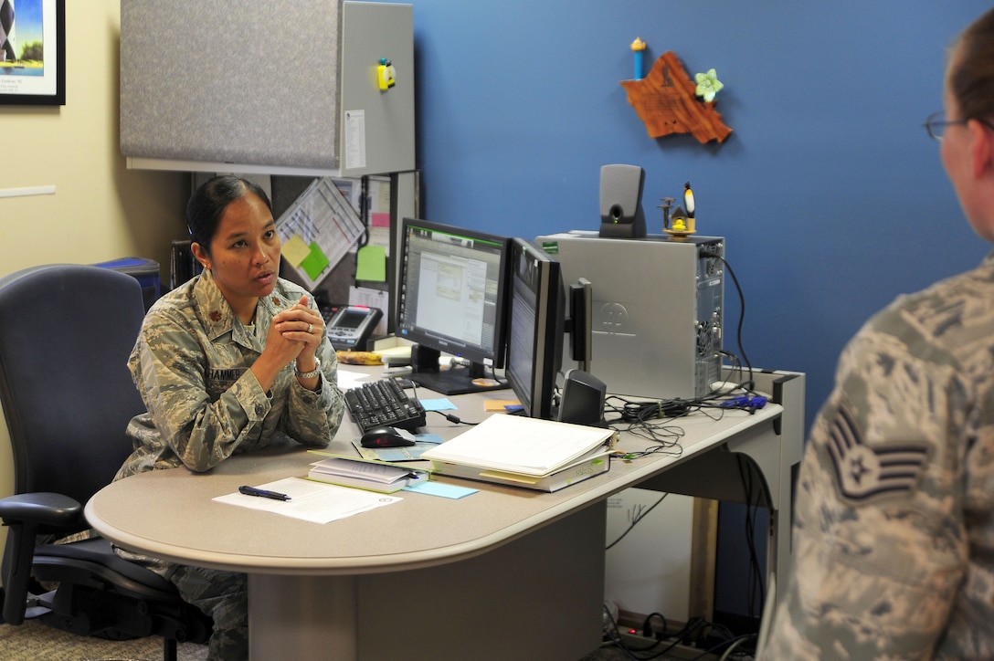 Maj. Elisa Hammer, 779th Aeromedical Squadron Bioenvironmental Engineering Flight chief, speaks with an Airman in her office, May 2, 2013, at Joint Base Andrews, Md. As the flight chief, Hammer?s job is to enforce worker protection against occupational health hazards, such as chemical, biological, radiological, nuclear and physical threats at JBA. (U.S. Air Force photos by Senior Airman Steele C. G. Britton)