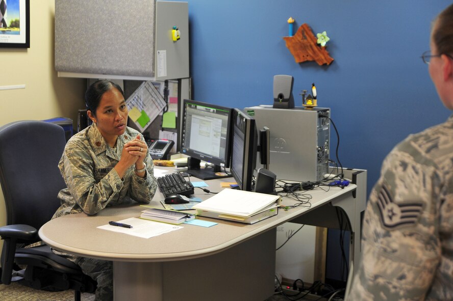 Maj. Elisa Hammer, 779th Aeromedical Squadron Bioenvironmental Engineering Flight chief, speaks with an Airman in her office, May 2, 2013, at Joint Base Andrews, Md. As the flight chief, Hammer?s job is to enforce worker protection against occupational health hazards, such as chemical, biological, radiological, nuclear and physical threats at JBA. (U.S. Air Force photos by Senior Airman Steele C. G. Britton)