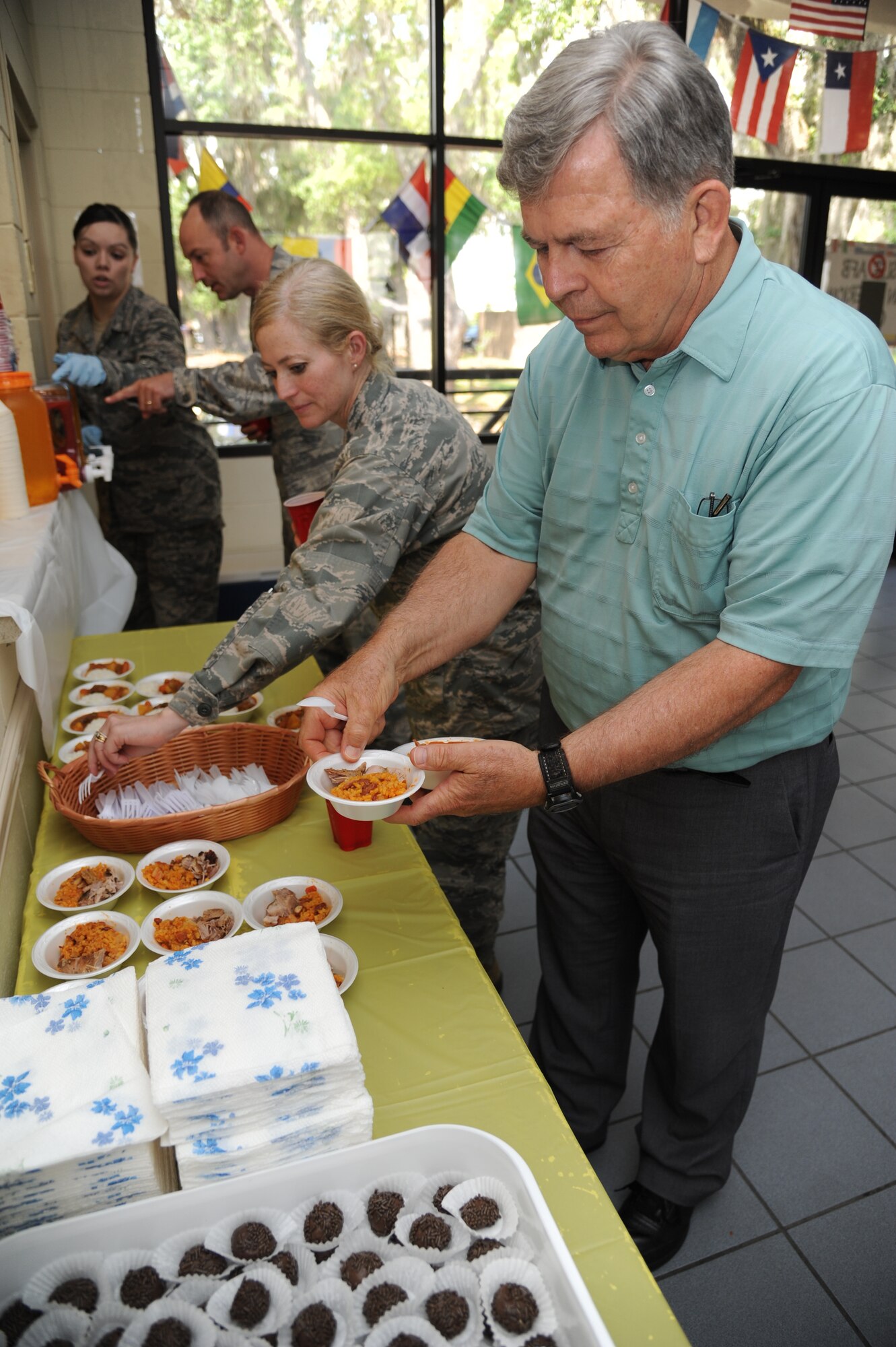 Lt. Col. Michelle Carns, 338th Training Squadron commander, and Stan Hall, 338th TRS, take part in the Latin-American Heritage Committee food sampling May 23, 2013, at the marina, Keesler Air Force Base, Miss.  The event also included a variety of beverages and music to showcase diversity on base.  (U.S. Air Force photo by Kemberly Groue)