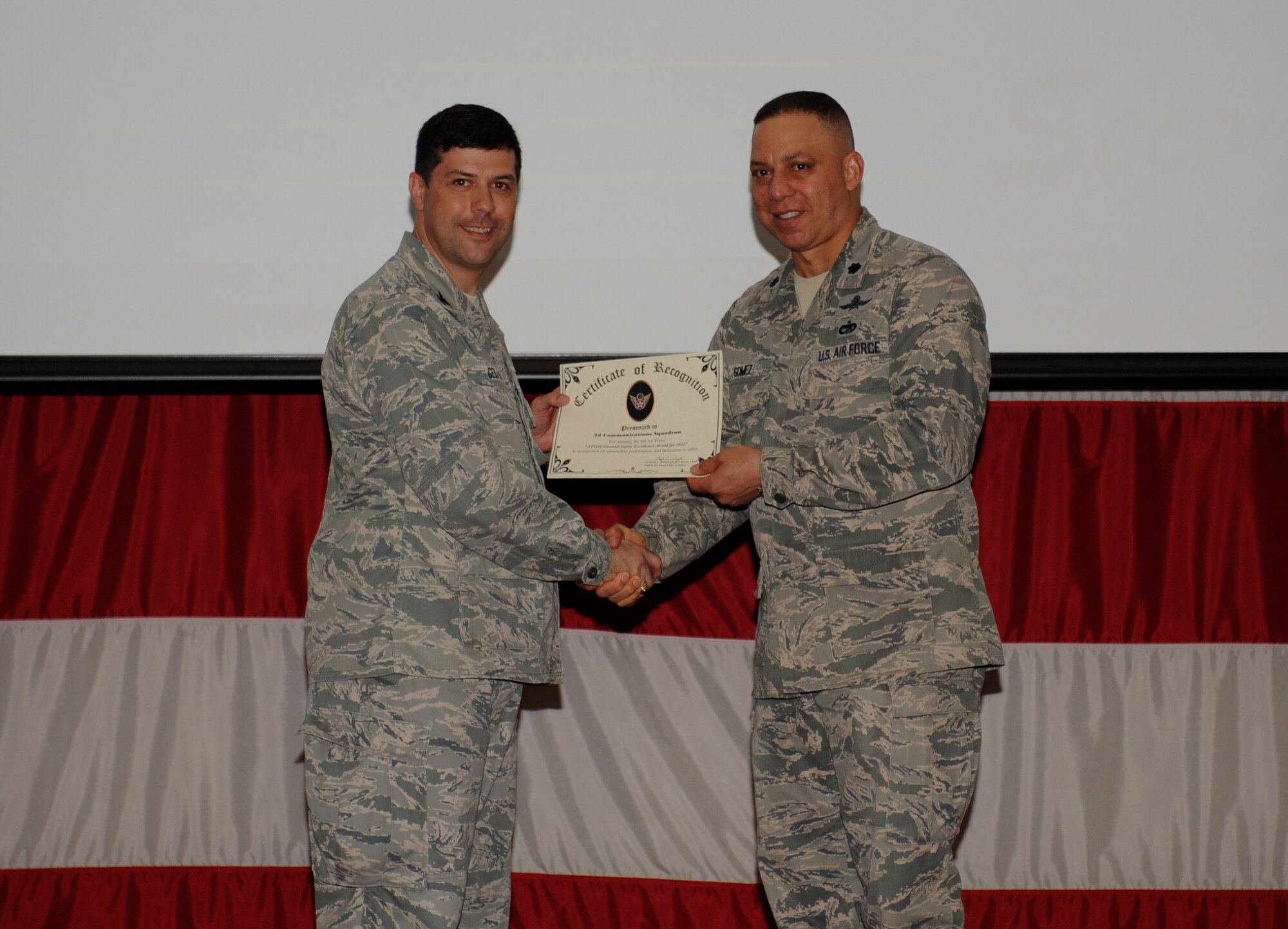 Lt. Col. Julio Gomez, 2nd Communications Squadron commander, accepts the 2012 8th Air Force Ground Safety Excellence Award on behalf of the 2nd CS from Col. Andrew Gebara, 2nd Bomb Wing commander, on Barksdale Air Force Base, La., May 23, 2013. (U.S. Air Force photo/Airman 1st Class Benjamin Gonsier)