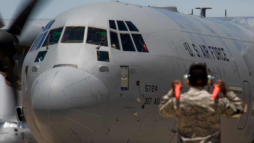 A U.S. Air Force Airman from the 317th Airlift Group marshals-in the newest C-130J May 22, 2013, at Dyess Air Force Base, Texas. Dyess has received 27 of 28 J-models, replacing the legacy fleet of the C-130 H-models. The C-130J is the newest generation of the C-130 Hercules which primarily performs the tactical portion of the airlift mission. The aircraft is capable of operating from rough, dirt strips and is the primary transport for air dropping troops and equipment into hostile areas. (U.S. Air Force photo by Senior Airman Jonathan Stefanko/Released)