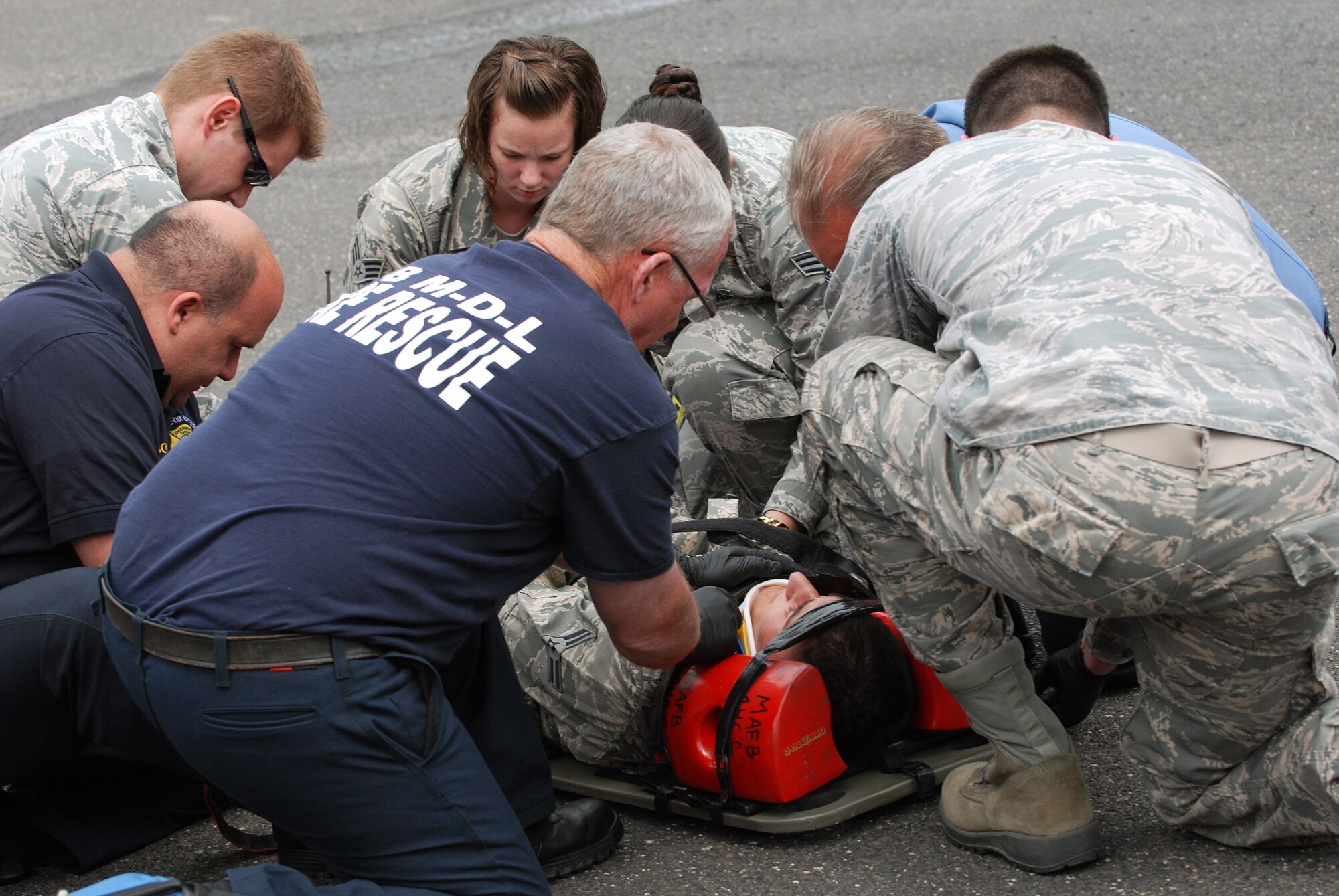 Joint base civilian and military first responders from the Joint Base Fire Department strap a mock patient to a transfer board in preparation for movement during a training exercise May 15, 2013, at Joint Base McGuire-Dix-Lakehurst, N.J. The training exercise was conducted as preparation for the summer months where incidents of pedestrians being struck by motor vehicles increases. (U.S. Army photo by Sgt. Darron Salzer/Released) 