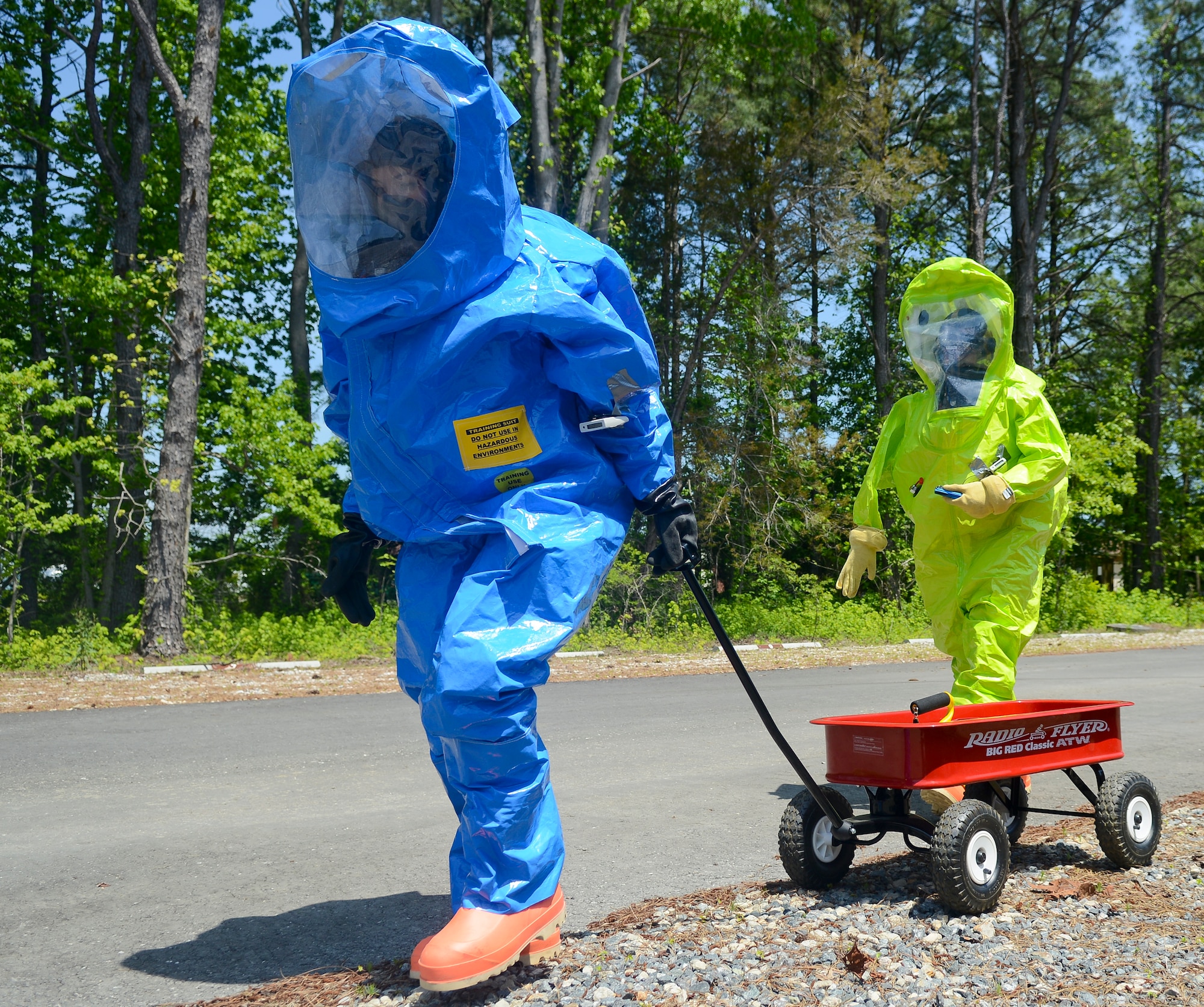 Emergency responders proceed to a contaminated building during a training exercise at Langley Air Force Base, Va., May 16, 2013. The participants wear these full-encapsulation suits in response to an unknown scenario to prevent what might be lethal contamination. (U.S. Air Force photo by Airman 1st Class Austin Harvill/Released)