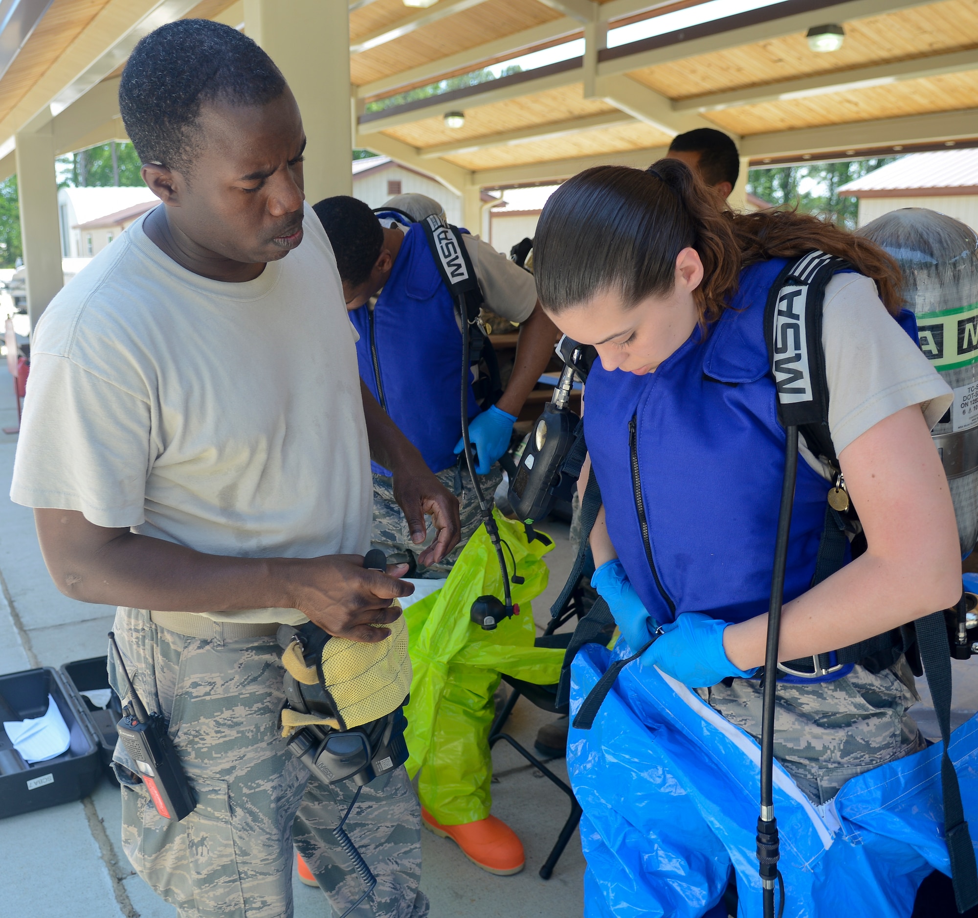 U.S. Air Force Senior Airman Jessica Kettering, 633rd Medical Group bioenvironmental engineering technician, straps on her full-encapsulating suit during a training exercise at Langley Air Force Base, Va., May 16, 2013. Because the suit is completely sealed, responders wear air tanks and masks in order to breathe. (U.S. Air Force photo by Airman 1st Class Austin Harvill/Released)