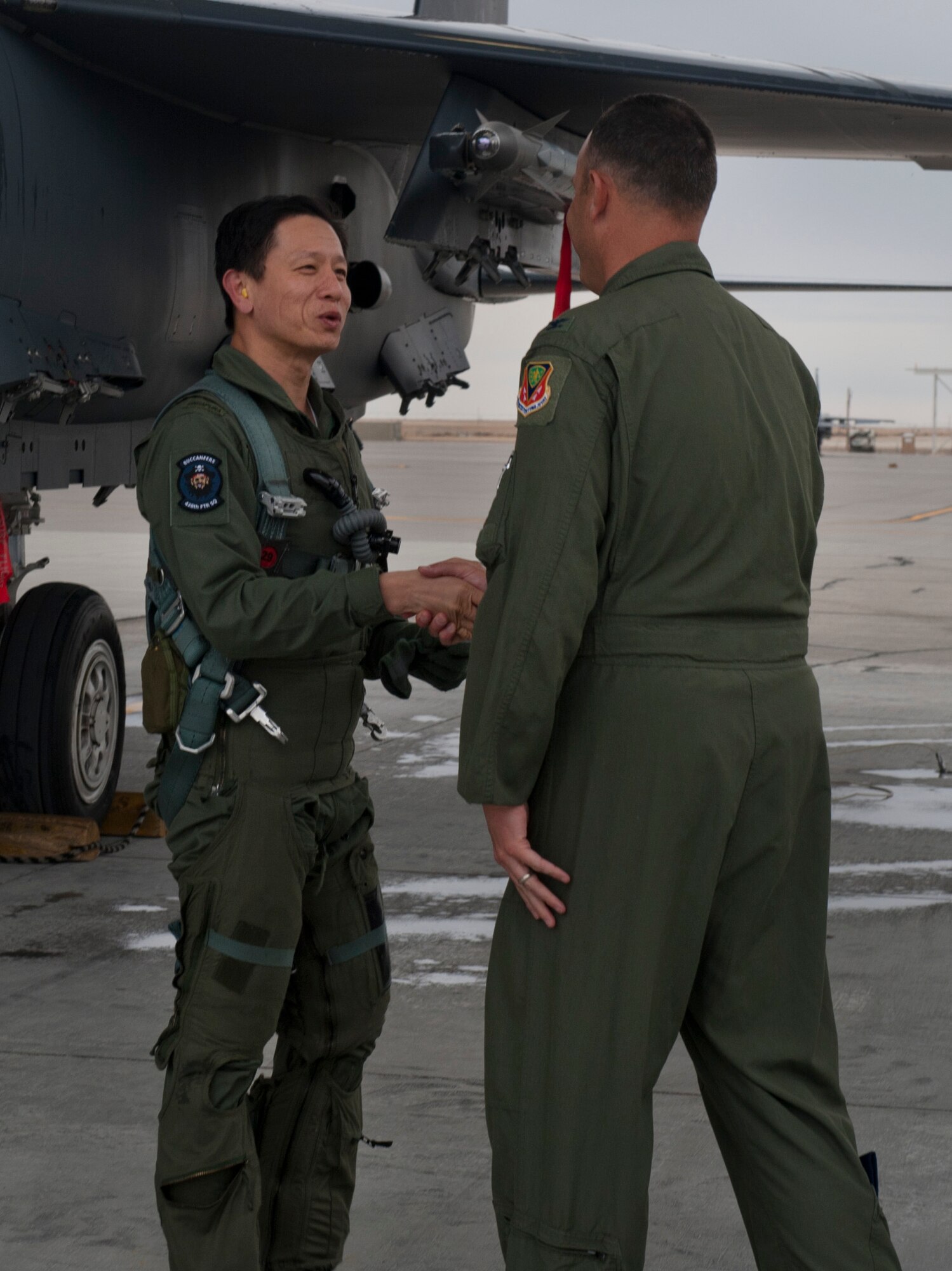 Republic of Singapore’s Air Combat Command Commander Col. Lim Tuang Liang shakes the hand of Col. Chris Short, 366th Fighter Wing commander, May 16, 2013 at Mountain Home Air Force Base, Idaho. Following Liang’s flight, a plaque representing the official inauguration for the new overhead aircraft shelters was revealed and will hang in the aircraft shelters for the 428th Fighter Squadron. (U.S. Air Force Senior Airman Heather Hayward/Released)