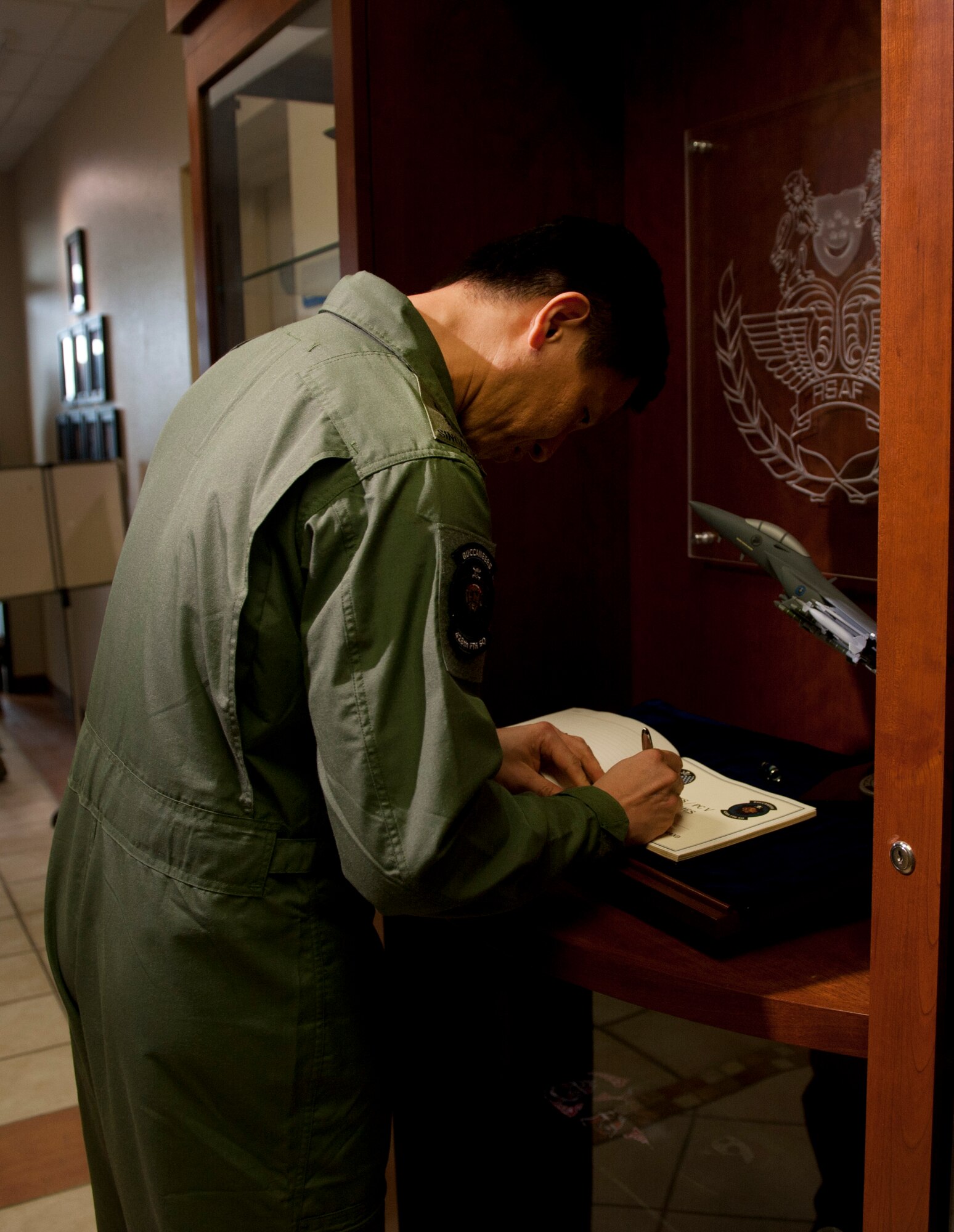 Republic of Singapore’s Air Combat Command Commander Col. Lim Tuang Liang signs the guestbook at the 428th Fighter Squadron May 16, 2013 at Mountain Home Air Force Base, Idaho. Every distinguished visitor that goes to the 428th FS is asked to sign the book. (U.S. Air Force Senior Airman Heather Hayward/Released)