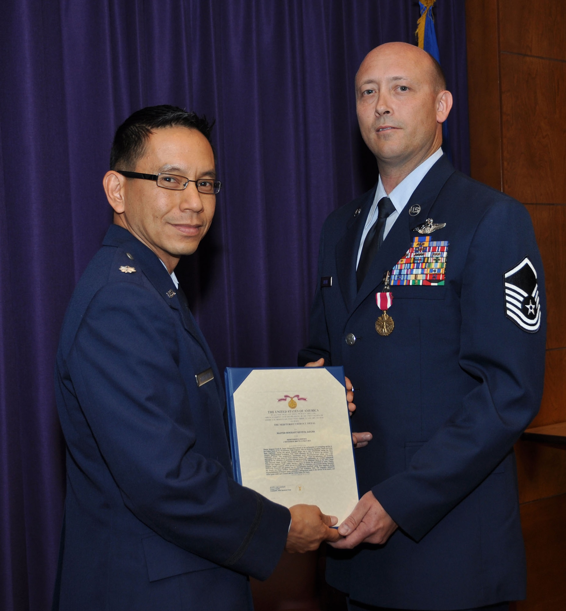 TRAVIS AIR FORCE BASE, Calif. -- Lt. Col. Gerard Guevara, 349th AMOS director of operations, congratulates Master Sgt Kevin Jaeger upon his retirement from the Air Force Reserves on his last day here. Jaeger served 29 years with the Air Force. (U.S. Air Force photo / Senior Master Sgt. Robert Wade) 
