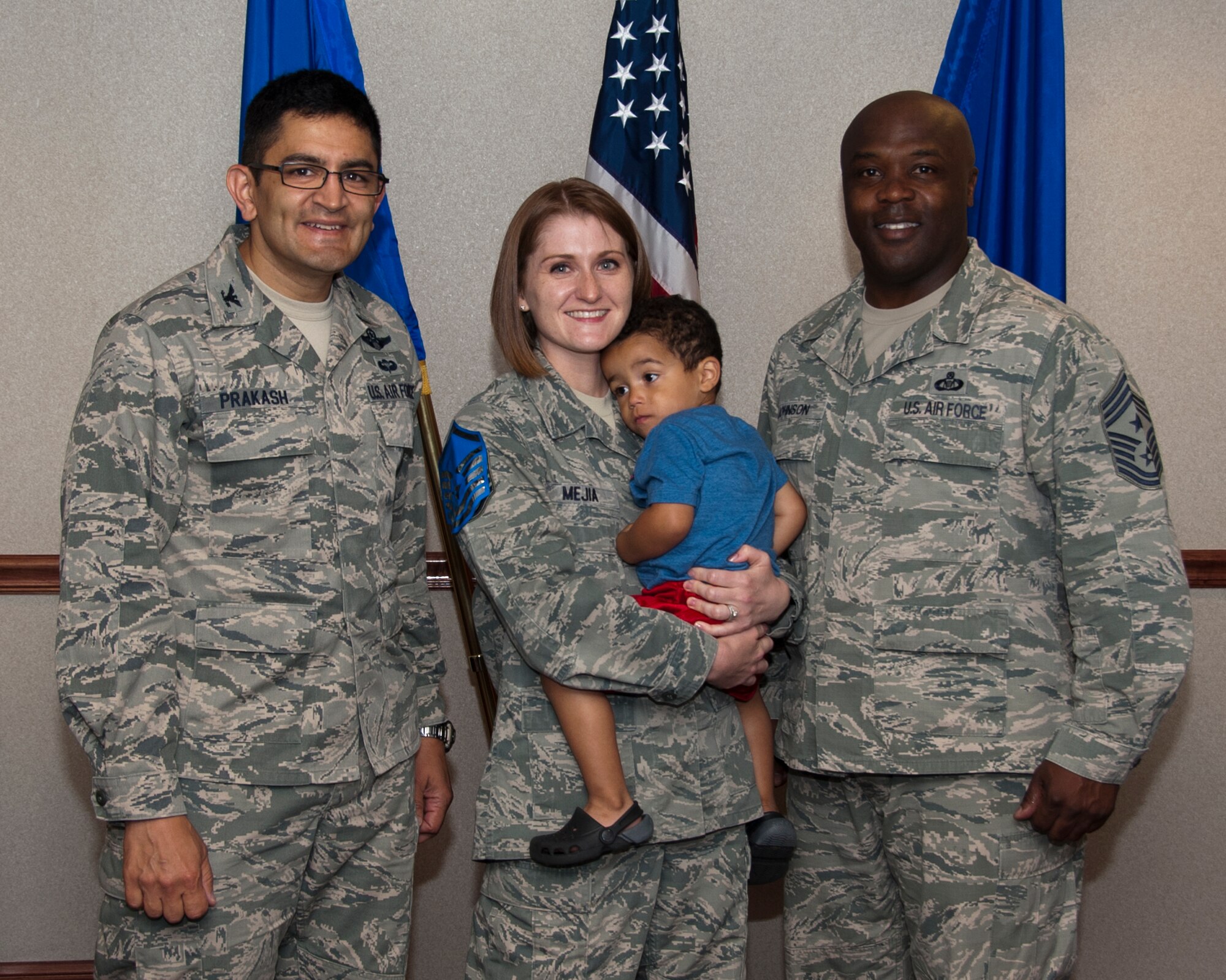 Col. Om Prakash, 82nd Training Wing vice commander and Command Chief Eric Johnson (pictured right), congratulate master sergeant promotee Anna Mejia as she holds her child and receives the commander's wingman of choice award and a promotion to the rank of master sergeant in the 82nd Training Wing conference room. She was congratulated on her professionalism and work ethic. (U.S. Air Force photo by Frank Carter)   