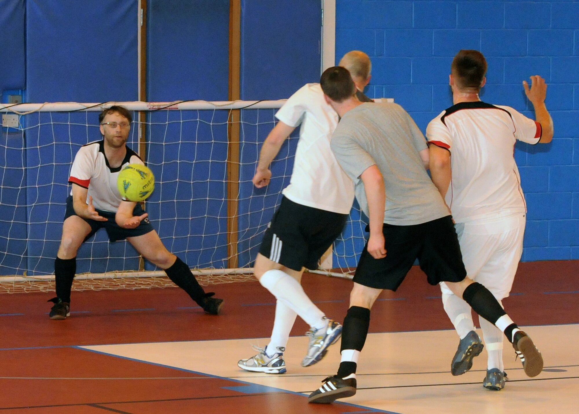 Barry King, goalkeeper for the 100th Civil Engineer Squadron team, stops a shot on goal from members of the 100th Maintenance Group team during an extramural soccer championship game May 23, 2013, at RAF Mildenhall, England. The 100th CES beat the 100th MXG five to one. (U.S. Air Force photo by Tech. Sgt. Neal X. Joiner/Released)
