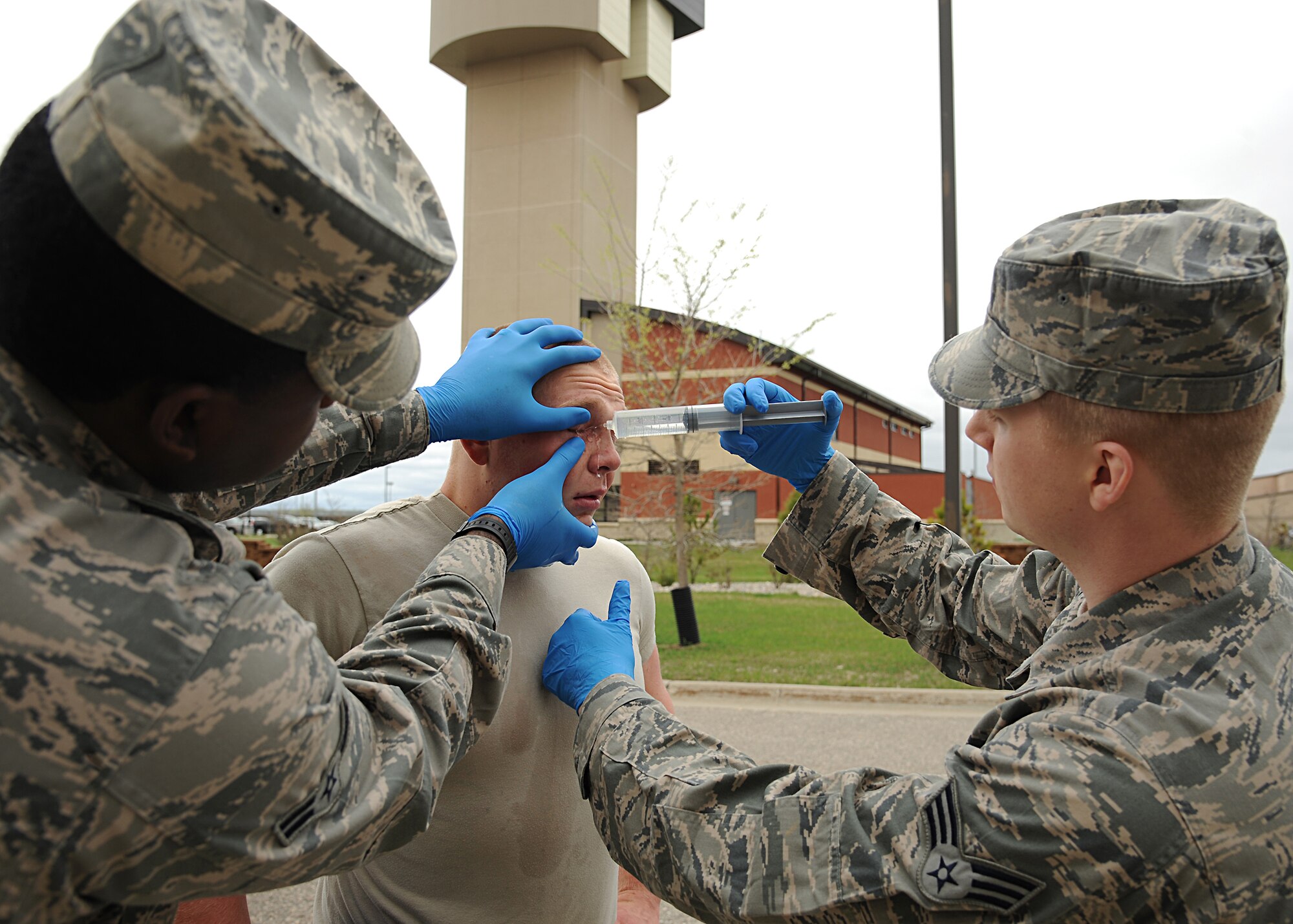 Medical technicians from the 319th Medical Group flush out Airman 1st Class Sean Egan’s eyes after the 319th Security Forces Squadron member was pepper sprayed for training purposes on May 21, 2013, at Grand Forks Air Force Base, N.D. The training required Airmen to be sprayed and fight off opponents while performing riot baton techniques for 30 seconds in three different obstacles. (U.S. Air Force photo/Airman 1st Class Xavier Navarro)  