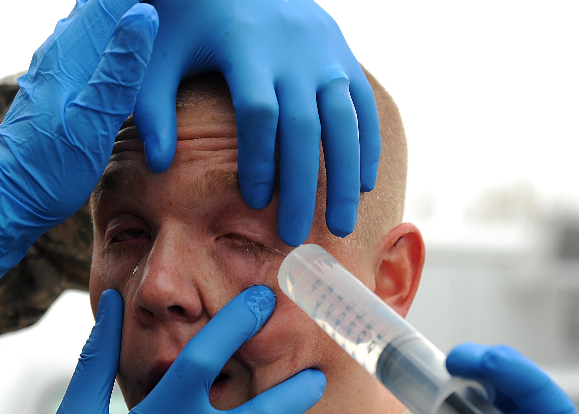 Airman 1st Class Sean Egan, 319th Security Forces Squadron, engages in combative drills Medical technicians from the 319th Medical Group flush out Airman 1st Class Sean Egan’s eyes after the 319th Security Forces Squadron member was pepper sprayed for training purposes on May 21, 2013, at Grand Forks Air Force Base, N.D. The training required Airmen to be sprayed and fight off opponents while performing riot baton techniques for 30 seconds in three different obstacles. (U.S. Air Force photo/Airman 1st Class Xavier Navarro)  