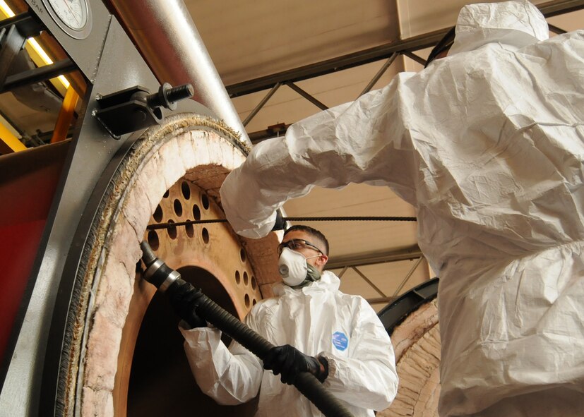 From left, Staff Sgt. Christian Ortega, 100th Civil Engineer Squadron heating, ventilation and air conditioning technician from Chicago, and Chief Master Sgt. Tracy Jones, 100th Air Refuleing Wing command chief from Phillips, Texas, clean the fire tubes in a 2,350 kilowatt burner unit May 23, 2013, at RAF Mildenhall, England. Jones assisted Ortega with the maintenance as part of the base’s “dirty jobs” program. (U.S. Air Force photo by Tech. Sgt. Neal X. Joiner/Released)