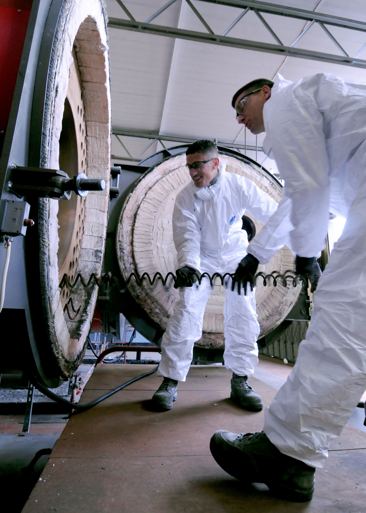 From left, Staff Sgt. Christian Ortega, 100th Civil Engineer Squadron heating, ventilation and air conditioning technician from Chicago, and Chief Master Sgt. Tracy Jones, 100th Air Refuleing Wing command chief from Phillips, Texas, conduct maintenance on a 2,350 kilowatt burner unit May 23, 2013, at RAF Mildenhall, England. Jones assisted Ortega with the maintenance as part of the base’s “dirty jobs” program; which gives leadership an opportunity to perform critical jobs across base, to see how they contribute to the mission. (U.S. Air Force photo by Tech. Sgt. Neal X. Joiner/Released)