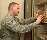 Senior Airman Ernest Trosen, 319th Contracting Flight contract administrator, organizes files for the contracting flight on May 16, 2013, on Grand Forks Air Force Base, N.D. The Walcott, N.D., native was named the base’s Warrior of the Week for the fourth week of May 2013. (U.S. Air Force photo/Airman 1st Class Zachiah Roberson)