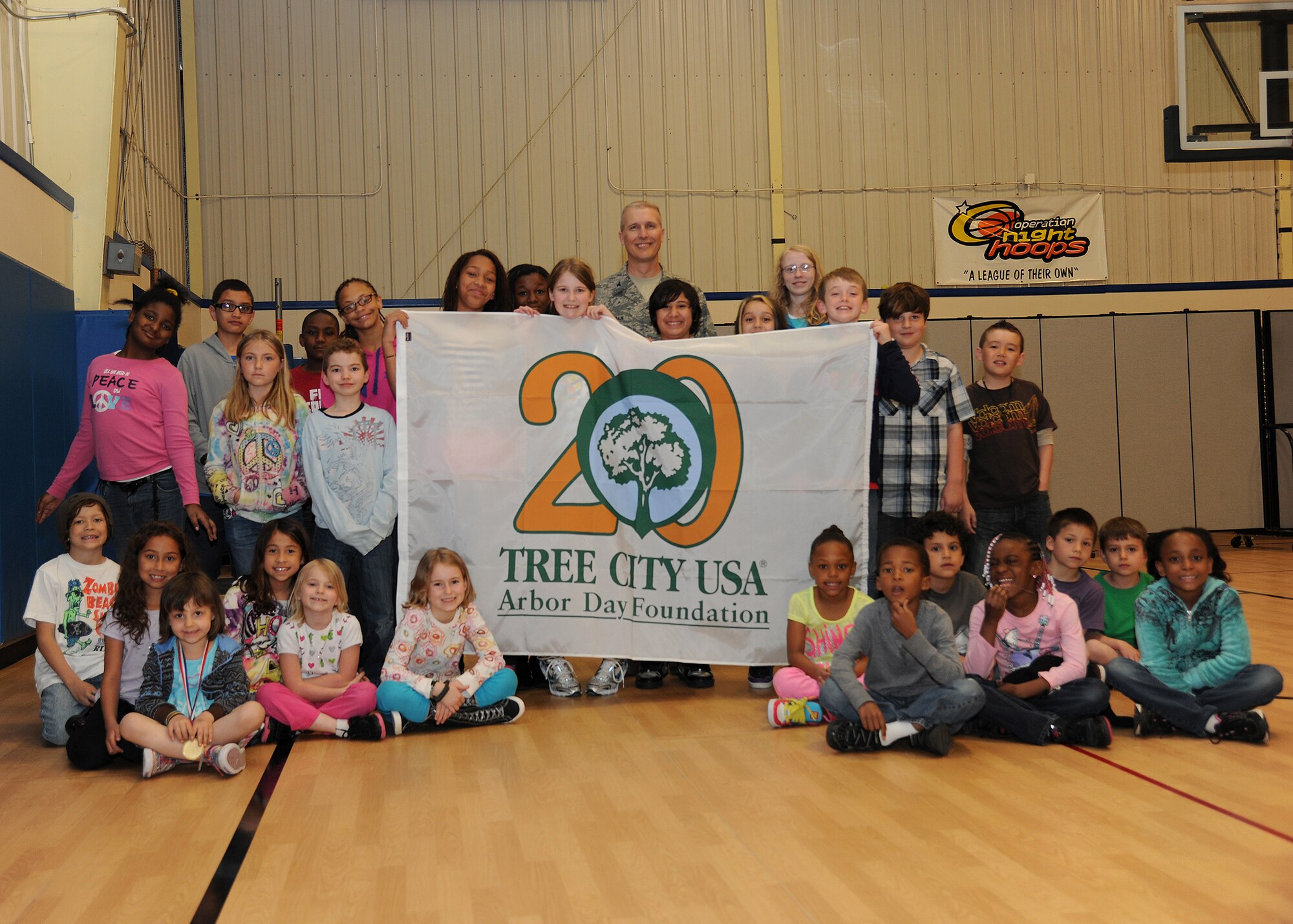 Col. Paul Bauman, 319th Air Base Wing commander, celebrates Arbor Day with children from the Youth Center on May 20, 2013, on Grand Forks Air Force Base, N.D. Seven new trees will be added to the installation as part of the base’s commitment to community forestry. (U.S. Air Force photo/Airman 1st Class Ashley Nicole Taylor)