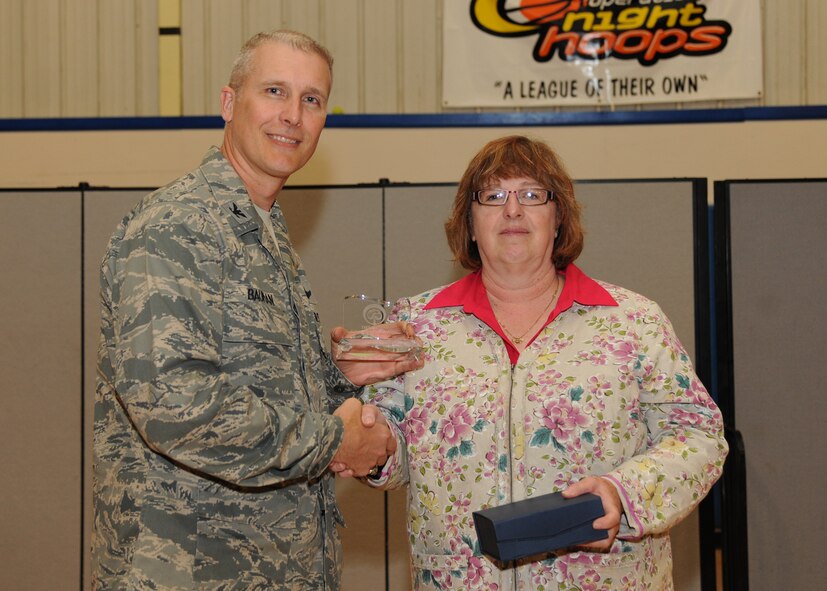 Col. Paul Bauman, 319th Air Base Wing commander, receives a Tree City USA trophy from Sharon Bartels, community forestry specialist with the North Dakota Forest Service, on May 20, 2013, on Grand Forks Air Force Base, N.D. The base has been the recipient of the Tree City USA Award for two straight decades. (U.S. Air Force photo/Airman 1st Class Ashley Nicole Taylor)