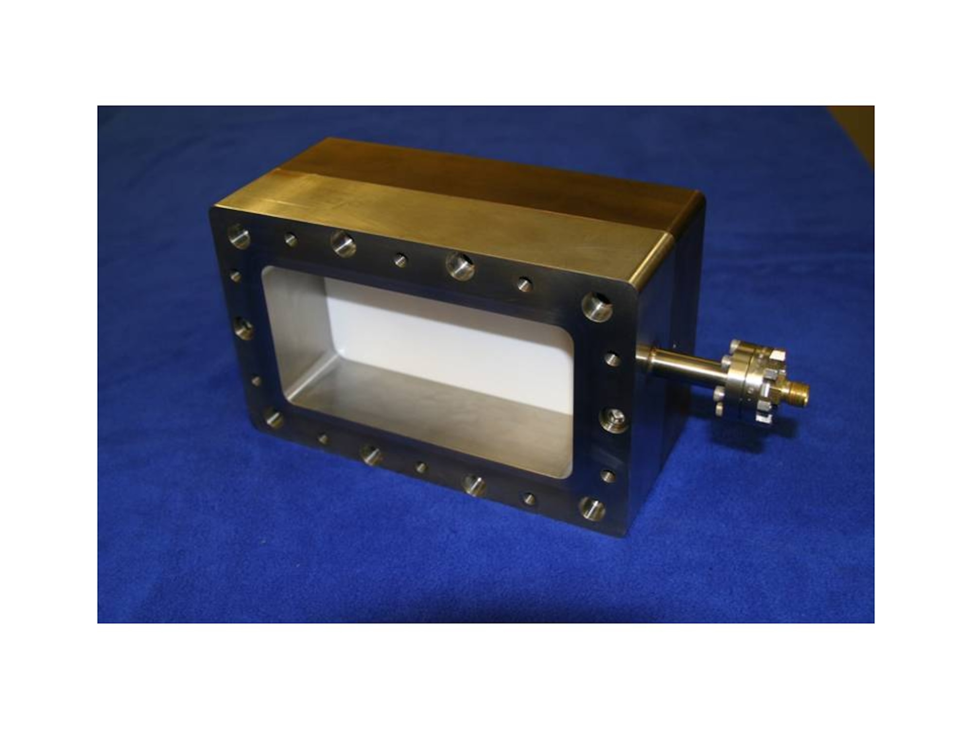 The window assembly from the pressure side.  The assembly is 8 3/4" wide, 5 1/2" high, and 3 7/8" thick.  The fitting on the right is a gas fitting for pressurizing the waveguide.  The window bolts directly to a standard WR 650 flange. (Voss Scientific Image)