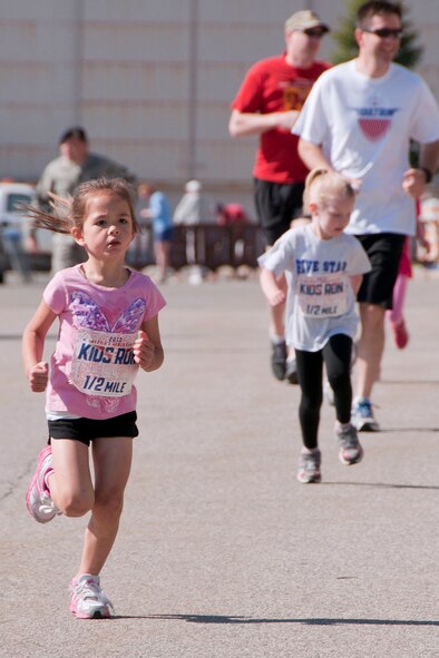 HANSCOM AIR FORCE BASE, Mass. -- Lua Savali, age 5, runs in the America's Armed Forces Kids Run outside the Base Exchange parking lot May 18 as part of Armed Forces Day. More than 25 children ranging in age two to 13 years old participated in the event which was hosted by the Youth Center. (U.S. Air Force photo by Mark Wyatt)