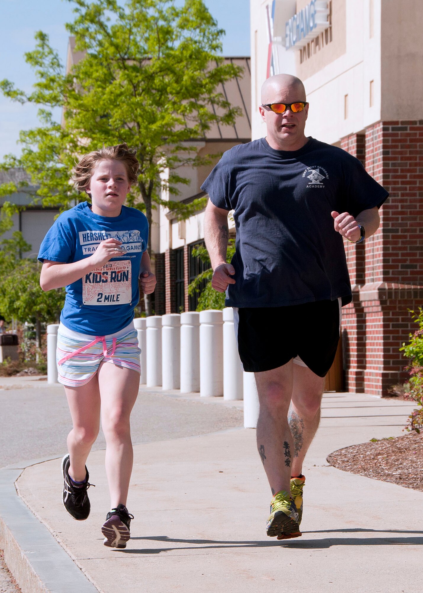 HANSCOM AIR FORCE BASE, Mass. -- Senior Master Sgt. Jason Dahlquist and his daughter Cora, age 11, run in the America's Armed Forces Kids Run outside the Base Exchange parking lot May 18 as part of Armed Forces Day. More than 25 children ranging in age two to 13 years old participated in the event which was hosted by the Youth Center. (U.S. Air Force photo by Mark Wyatt)
