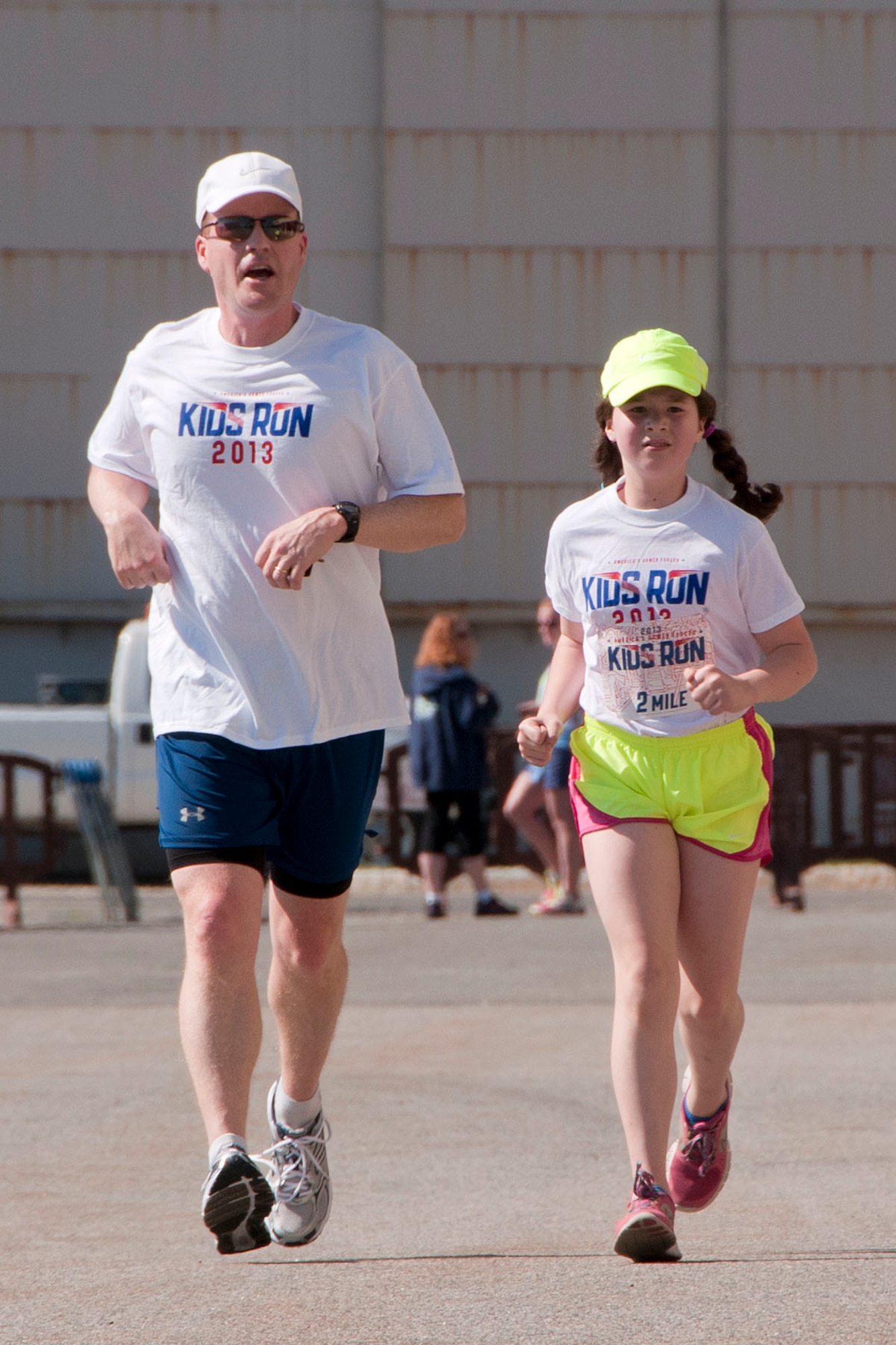 HANSCOM AIR FORCE BASE, Mass. -- Col. Michael Claffey and his daughter Aislinn, age 11, run in the America's Armed Forces Kids Run outside the Base Exchange parking lot May 18 as part of Armed Forces Day. More than 25 children ranging in ages two to 13 years old participated in the event which was hosted by the Youth Center. (U.S. Air Force photo by Mark Wyatt)