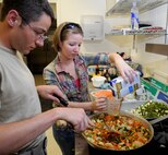 2nd Lt. Dan Venable, the air operations flight officer for the 71st Operations Support Squadron, left, and Staff Sgt. Nicole Curran, the NCO in charge of mission services for the 71st OSS Weather Flight, cook vegetable stir fry during the Singles’ International Gourmet Meal Opportunity held May 20 in the Community Chapel Activity Center at Vance Air Force Base, Okla. (U.S. Air Force photo/ Senior Airman Frank Casciotta)