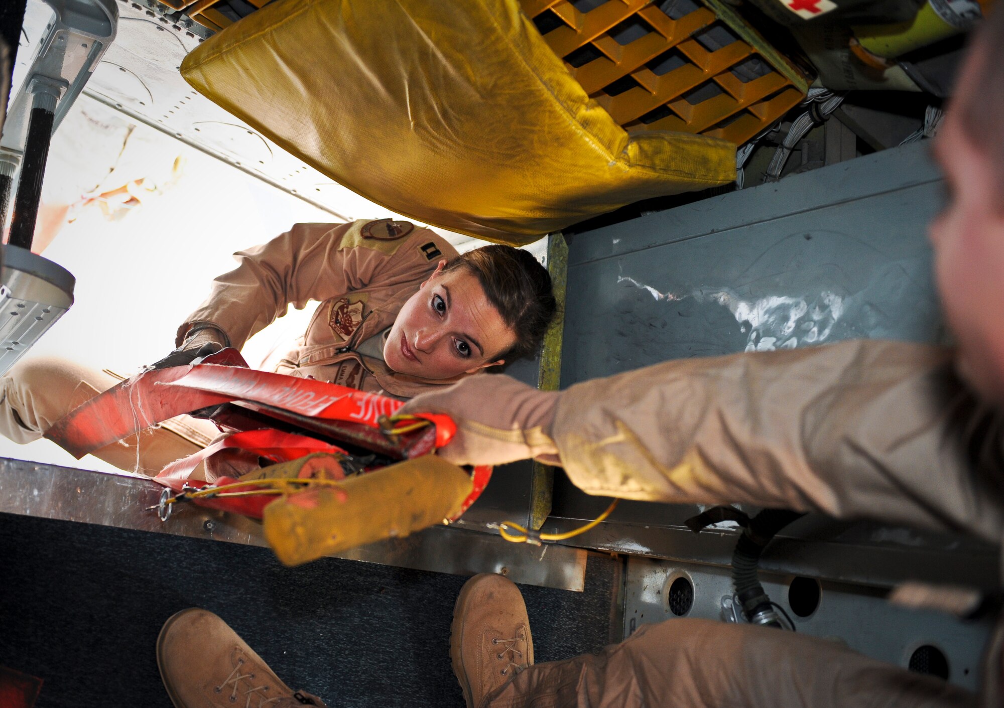 Capt. Emma House hands Senior Airman Rich Bradford safety lines during pre-flight checks on aircraft “57-1419,” May 18, 2013, at the 379th Air Expeditionary Wing in Southwest Asia. House is a 340th Expeditionary Air Refueling Squadron aircraft commander and Bradford is a 340th EARS boom operator. Both are deployed from Scott Air Force Base, Ill. Aircraft 57-1419 is a KC-135 Stratotanker deployed from the 190th Air Refueling Wing of the Kansas Air National Guard. (U.S. Air Force photo/Senior Airman Benjamin Stratton)