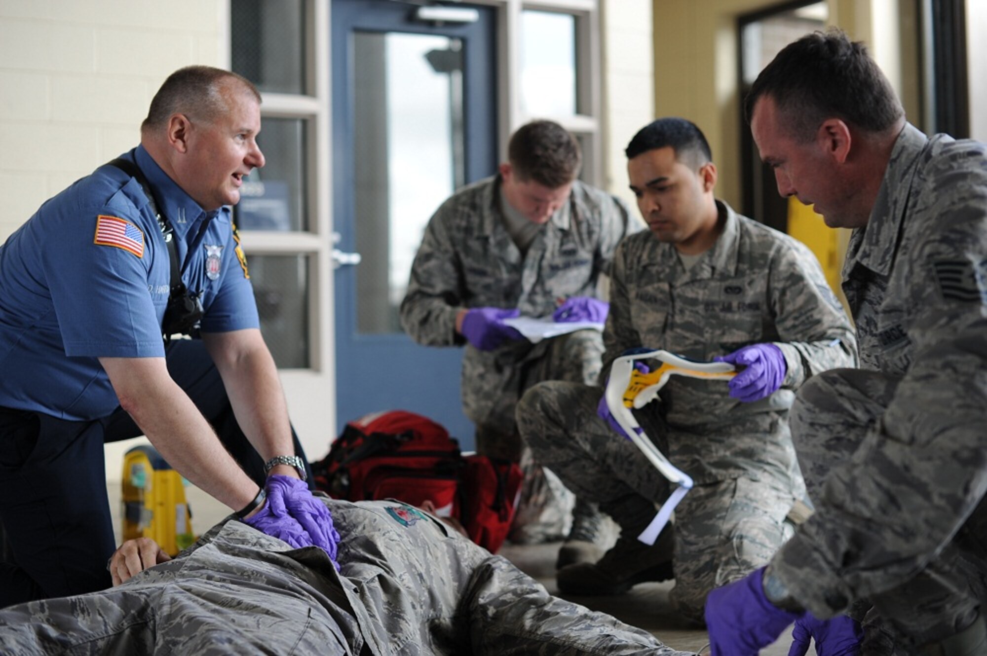 Fire Capt. David Harris performs routine checks on Tech. Sgt. John Randall who is playing the role of a person with a possible spinal cord injury May, 21, 2013, at Joint Base McGuire-Dix-Lakehurst, N.J. Harris, 87th Civil Engineer Squadron paramedic, and Randall, 147th Reconnaissance Wing firefighter at Ellington Field, Texas, are two of many emergency medical service providers recognized during National EMS Week annually. (U.S. Air Force photo by Airman Sean M. Crowe/Released)