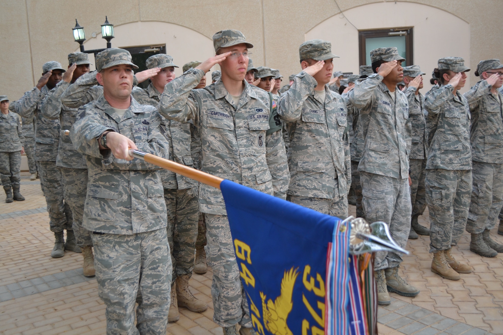 Members of the 64th Expeditionary Security Forces Squadron offer a salute during the retreat ceremony as part of the Police Week activities at Eskan Village in Southwest Asia, May 15, 2013. (U.S. Air Force photo/Staff Sgt. Jason Colbert)