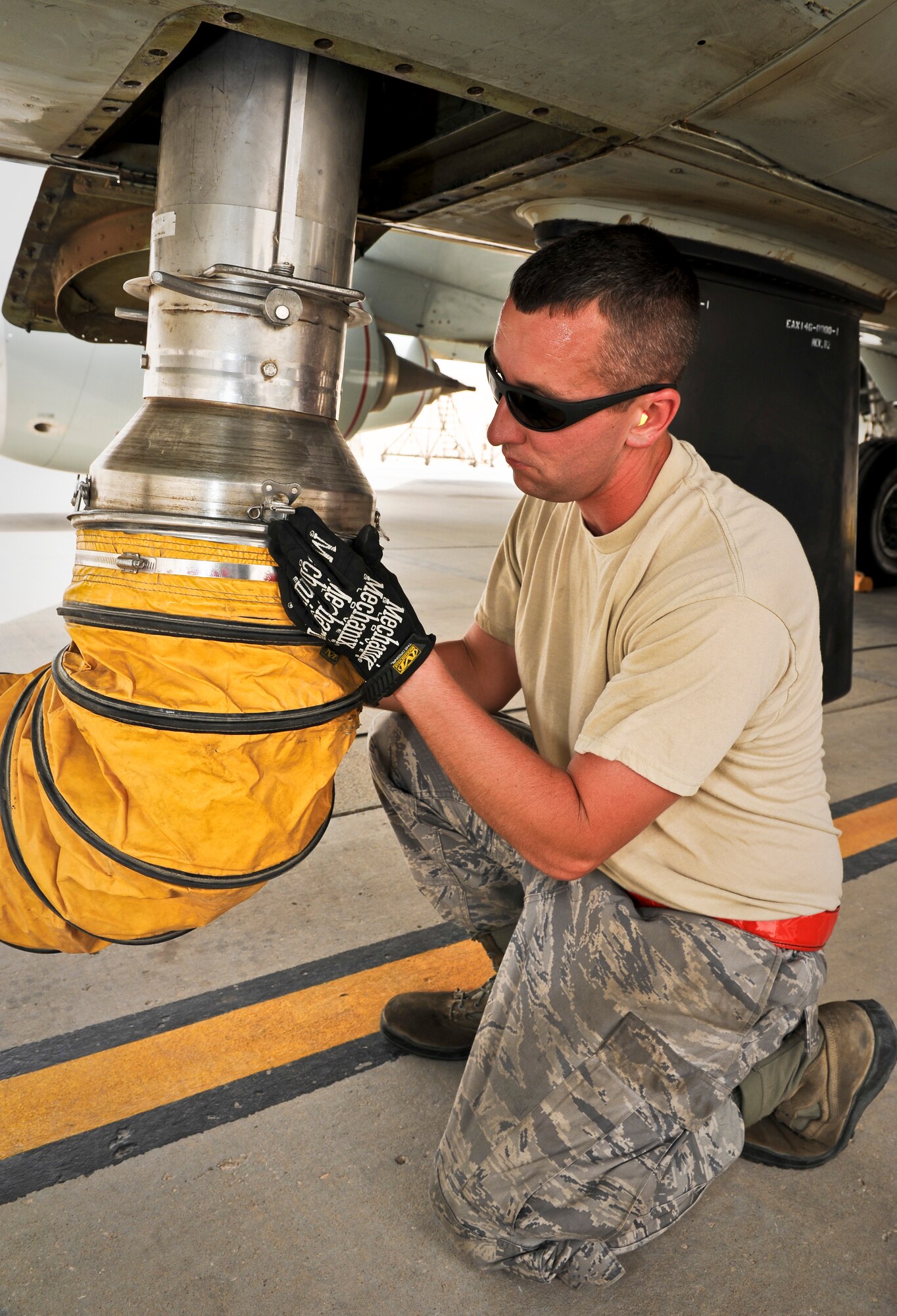Staff Sgt. Cody Meyers connects an air conditioning tube attachment to a recently arrived RC-135 Rivet Joint May 22, 2013, at the 379th Air Expeditionary Wing in Southwest Asia. Meyers is a 763rd Aircraft Maintenance Unit hydraulics craftsman deployed from Offutt Air Force Base, Neb. (U.S. Air Force photo/Senior Airman Benjamin Stratton)