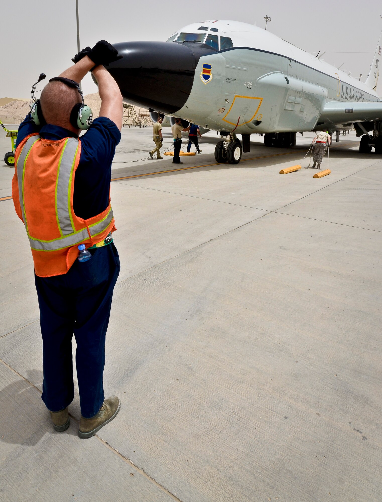 Staff Sgt. Robert Brushel directs a RC-135 Rivet Joint to its parking location after returning from a mission May 22, 2013, at the 379th Air Expeditionary Wing in Southwest Asia. Brushel is a 763rd Aircraft Maintenance Unit crew chief deployed from Offutt Air Force Base, Neb. (U.S. Air Force photo/Senior Airman Benjamin Stratton)