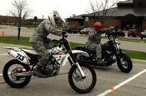 Tech. Sgt. Emily Wilczek, Airman Dormitory Leader, left, competes against Master Sgt. Scott Freed, 319th Air Base Wing Safety Office, in the slow race portion of the Motorcycle Rally and Safety Fair as part of a wing safety standdown day May 17, 2013, at Grand Forks Air Force Base, N.D. The object of the slow race is for riders to be the first to cross the finish line while riding their bikes as slowly as possible from one end of the parking lot to the other without losing their balance. Wilczek was named the overall winner of this year’s slow race. (U.S. Air Force photo/Staff Sgt. Susan L. Davis)