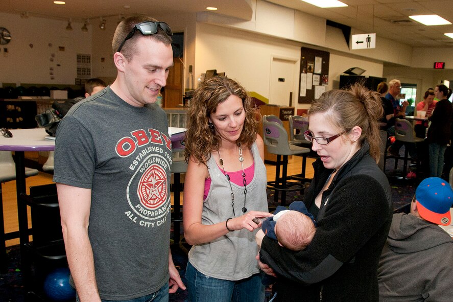 HANSCOM AIR FORCE BASE, Mass. -- Key Spouse Heather Julseth (center), talks to Capt. Alex Keller, Command, Control, Communications, Intelligence and Networks Directorate, and his wife Erin at a Hearts Apart event at the Hanscom Lanes Bowling Center May 22. Julseth and 10 other volunteers make sure they establish and maintain contact with families of deployed members, provide information and referral to base and community resources and promote individual, family and unit readiness (U.S. Air Force photo by Mark Wyatt)
