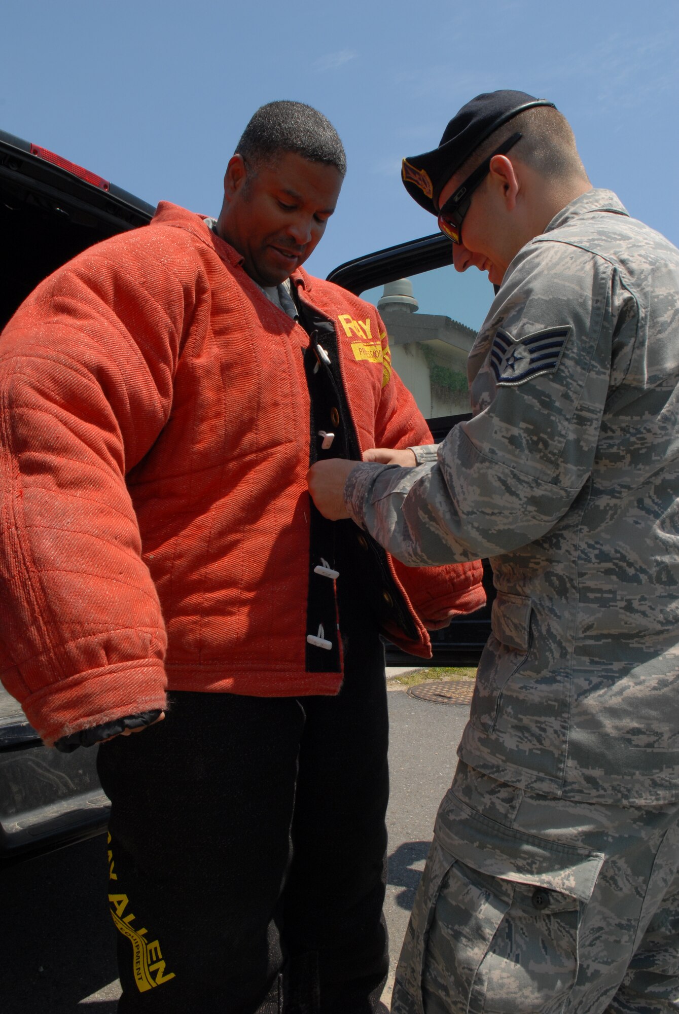 KUNSAN AIR BASE, Republic of Korea – Chief Master Sgt. Phillip Robinson, 8th Fighter Wing command chief, watches as Staff Sgt. Andrew Van Arb, 8th Security Forces Squadron member buttons up a bite suit, at Kunsan Air Base, Republic of Korea, May 14, 2013. The 8th SFS observed National Police Week with several events including the working-dog demonstration. (U.S. Air Force photo by Staff Sgt. Tong Duong/ Released)