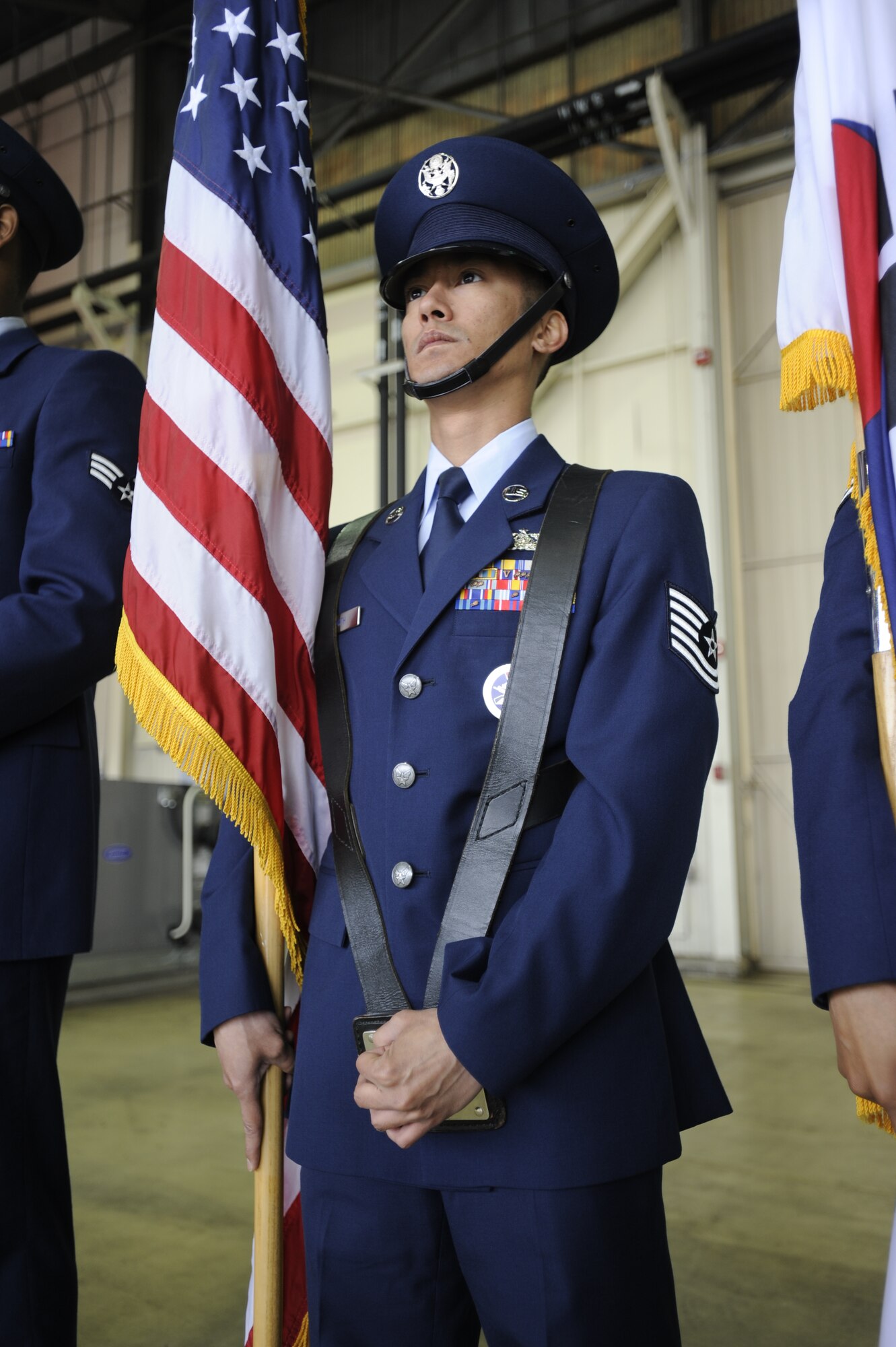 Tech. Sgt. Kristoffer Smith, 8th Fighter Wing NCO in charge of knowledge operations management, bears the national colors during a wing change of command ceremony at Kunsan Air Base, Republic of Korea, May 10, 2013. Smith was named Kunsan’s “Pride of the Pack” recipient April 29 to May 3. (U.S. Air Force photo by Staff Sgt. Tong Duong/Released)