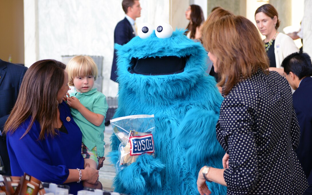 Martha Roby holds her 4-year-old son, George, as they greet Sesame Street's Cookie Monster during a biannual USO care package service project event on Capitol Hill in Washington, D.C., May 22, 2013. DOD photo by Army Sgt. 1st Class Tyrone C. Marshall Jr.