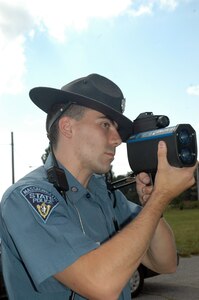 Massachusetts State Police Trooper Matt Lavoie trains an advanced laser speed detector on a car at the Massachusetts Military Reservation in early September. Troopers are cracking down on motorists who are violating traffic laws on the post.