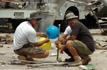 Mark Beirne (left) and Alan Perez tie balloons filled with explosive gas to a detonation stand to simulate an exploding truck during exercise Vigilant Guard Sept. 16 in Guam. Vigilant Guard tests the Guardâ€™s capabilities and abilities as a first military responder in support of the governor and the Emergency Management Agency after a terrorist attack. Many local, federal, military and civilian agencies are participating.
