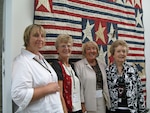 (Left to right) Donna J. Birtwistle, Mavis Olsen, Marlene Wallace and Penny Eakin stand before their patchwork quilt at the Women in Military Service for America Memorial, Sept. 17, 2008. The quilt honors military women who've died during the global war on terrorism.