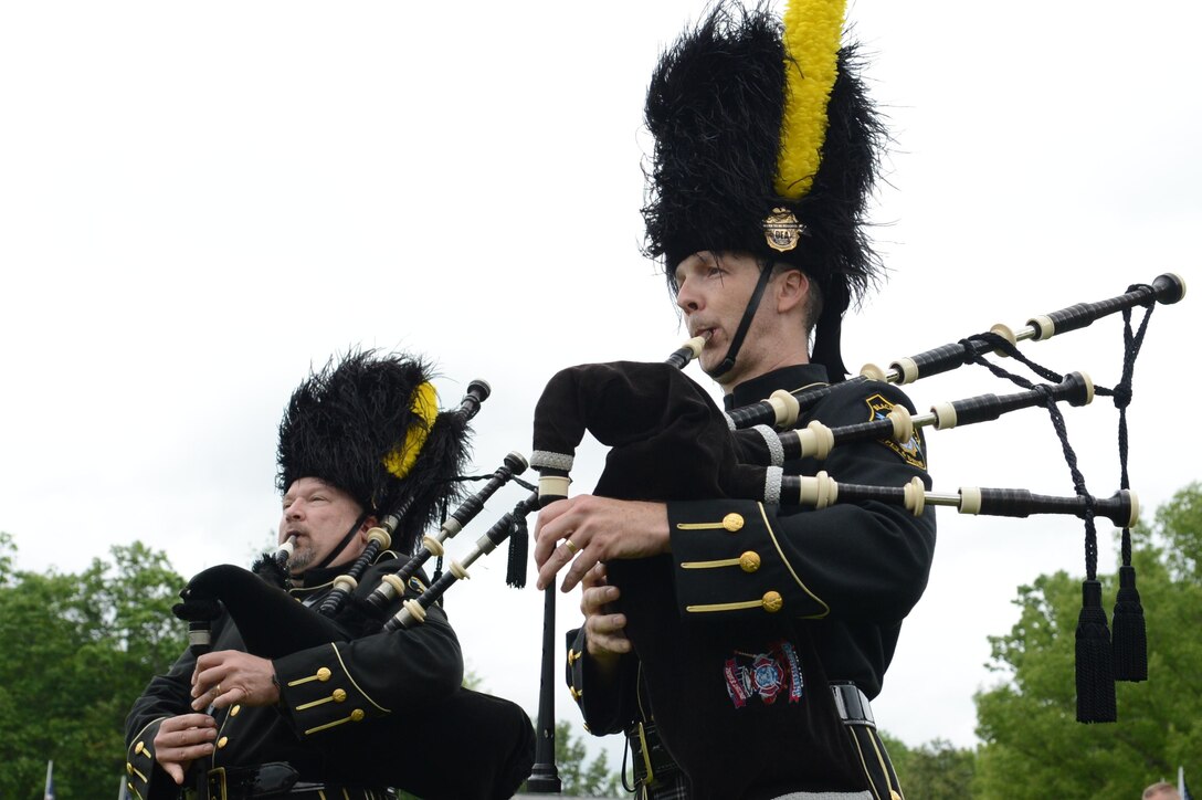 James Farnsworth, left, and Mike Galu, Drug Enforcement Agency Black & Gold Pipes & Drums Band members, played their bagpipes during the ceremony following a pre-Memorial Day formation run on May 23, 2013. Marine Corps Base Quantico hosted the run with each Quantico-based unit carrying their organizational colors from the National Museum of the Marine Corps to the Veterans Administration Quantico National Cemetary. In addition to all the Marine units on base, the FBI Academy, Naval Health Clinic Quantico and the Drug Enforcement Administration Training Academy also joined in the run.