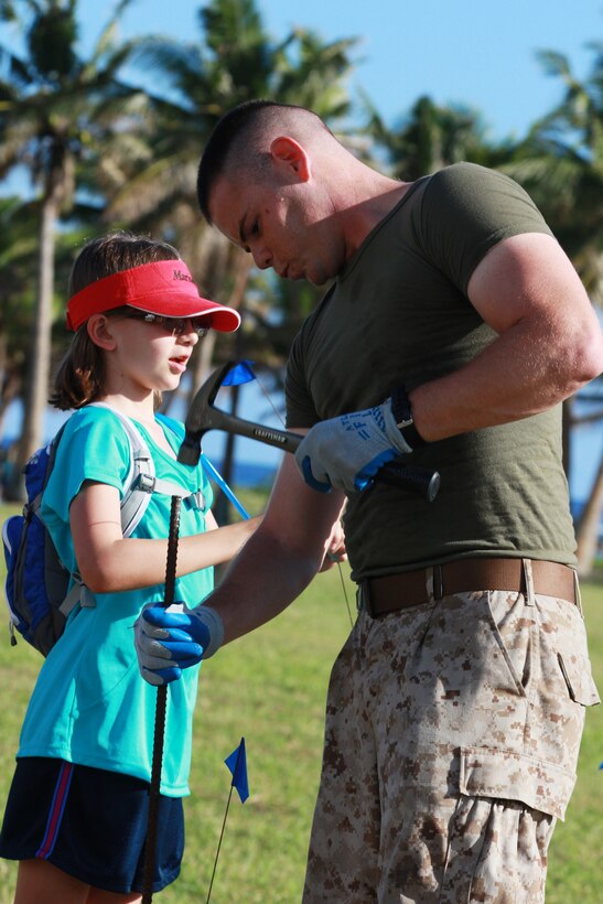 Corporal Christopher B. Henderson, Marine Corps Activity Guam Training NCO and native of Van Buren Arkansas hammers in rebar to make holes for building a flag display for Memorial Day, May 25, 2013, Asan Beach, Guam.  Marines, Sailors, Airmen and Army National Guardsmen participated with local volunteers and the National Park Service to commemorate Memorial Day by honoring service members and civilians who died in the Japanese invasion, occupation and United States liberation of Guam during World War II.