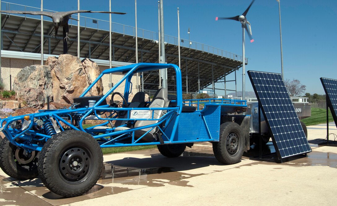 The Electrical and Computer Engineering Department's solar-powered vehicle sits on display in front of Falcon Stadium May 24, 2013. Behind the vehicle is a solar- and wind-powered turbine that can charge the vehicle and other electrical appliances. Constructing the trailer was a capstone project for a group of cadets majoring in electrical engineering. (U.S. Air Force photo/Don Branum)