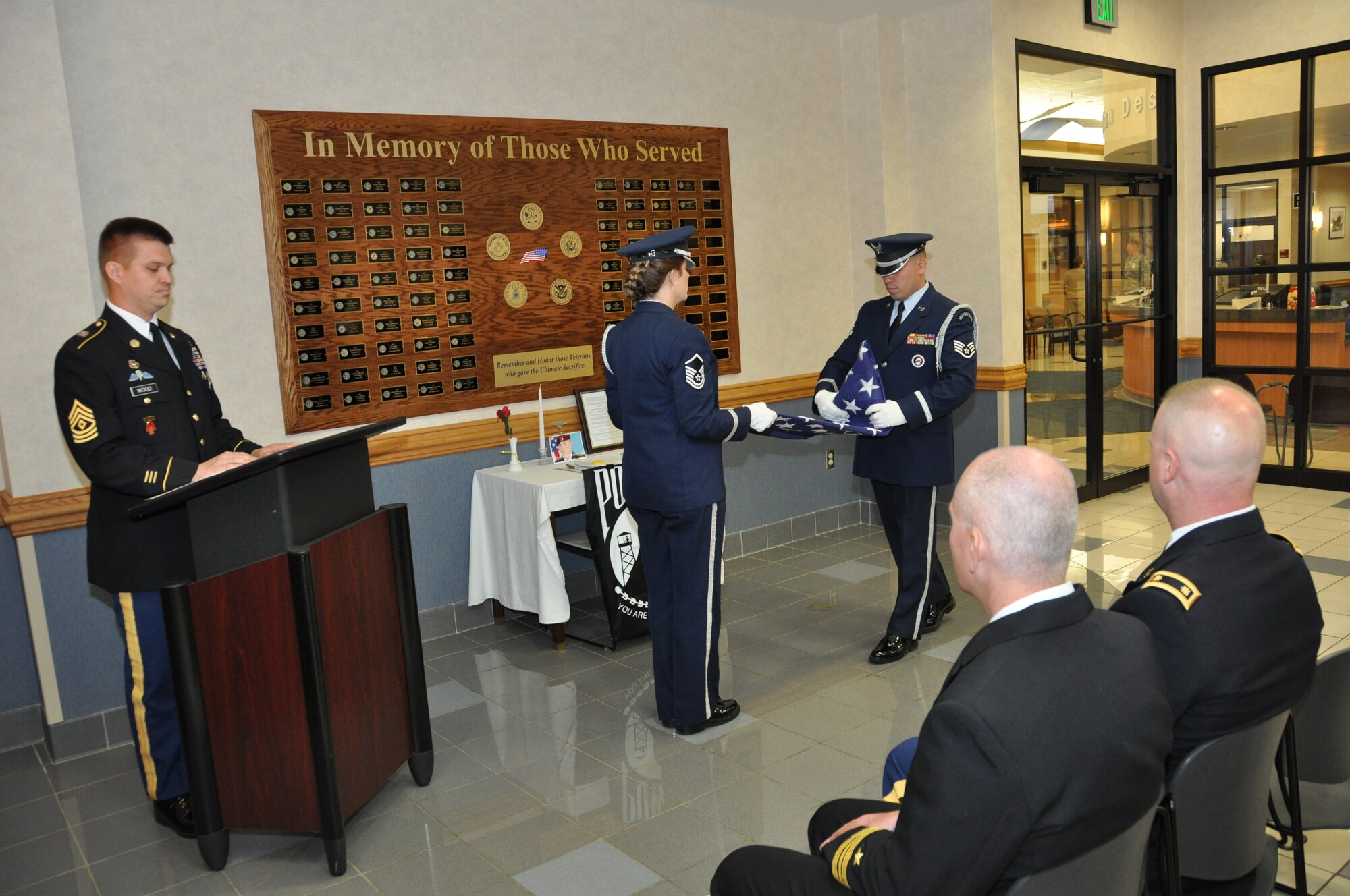 In honor of Memorial Day, Buffalo Military Entrance Processing Station 1st Sgt. Dwayne Wood (left), U.S. Army, narrates a flag fold ceremony performed by U.S. Air Force Master Sgt. Lisa Sveda and Staff Sgt. Edwin Castro, Niagara Falls Air Reserve Station Honor Guard, May 24, 2013 during a ceremony hosted by MEPS at the air base.   This solemn event was to honor those who have made the ultimate sacrifice in all branches of the Armed Forces by remembering their devotion and loyalty to the nation, its citizens, and our values.  (U.S. Air Force photo by Master Sgt. Kevin Nichols)