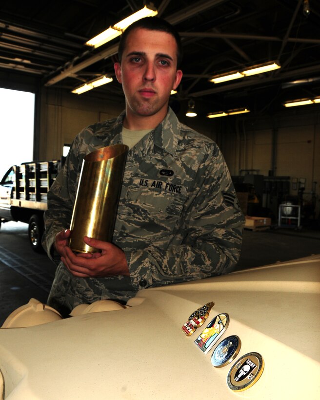 Senior Airman Patrick Debo, 914th Logistics Readiness Squadron, Vehicle Maintainer displays a 105mm spent round and coins at the Niagara Falls Air Reserve Station, NY on May 15, 2013. Debo received the 105mm shell and coins from commanders and units for appreciation of outstanding performance and volunteering for additional duties while on a six month deployment to Kyrugastan and Afghanistan recently. (US Air Force photo by Peter Borys)