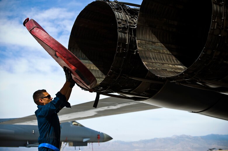 Staff Sgt. Kevin Colon removes exhaust covers from a B-1B Lancer during a Green Flag exercise May 21, 2013, at Nellis Air Force Base, Nev. Green Flag-West provides a realistic close-air support training environment for forces preparing to support worldwide combat operations. Colon is a 7th Aircraft Maintenance Squadron crew chief from Dyess Air Force Base, Texas. (U.S. Air Force photo/Airman 1st Class Christopher Tam)